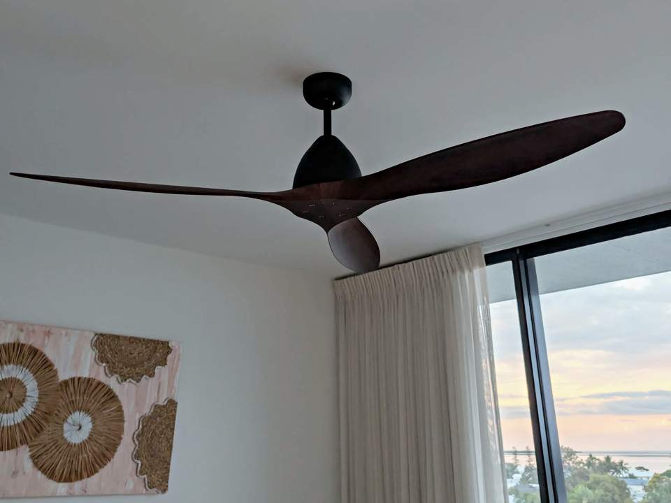 Timber-look three-blade ceiling fan installed in a bedroom